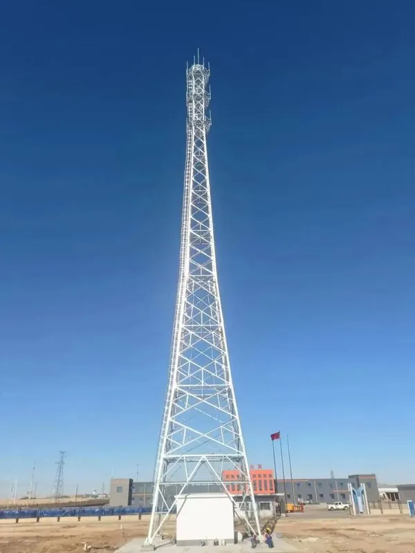 Galvanized communication tower installed beside a ground equipment shelter