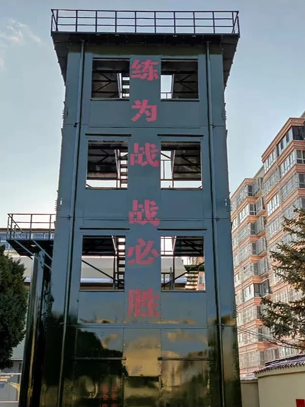 Olive green enclosed firefighter training tower with practice windows, side balcony and roof guardrail