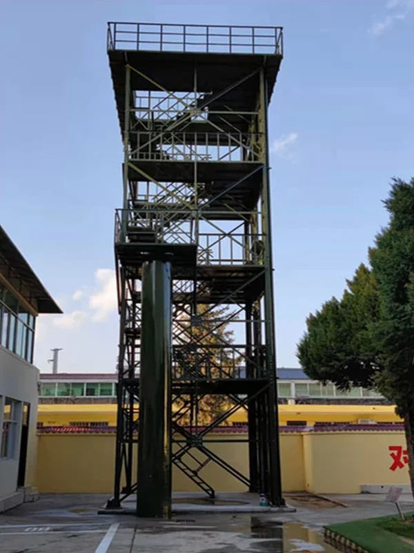 Open steel-frame fire training tower with internal stairs, floor platforms and central training shaft