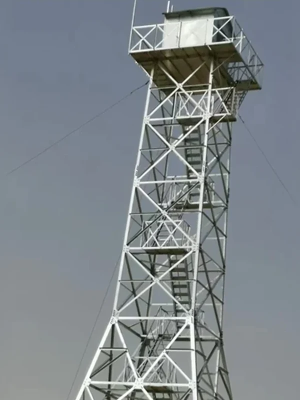 Guyed steel monitoring tower with enclosed top cabin, external platform and internal access ladder