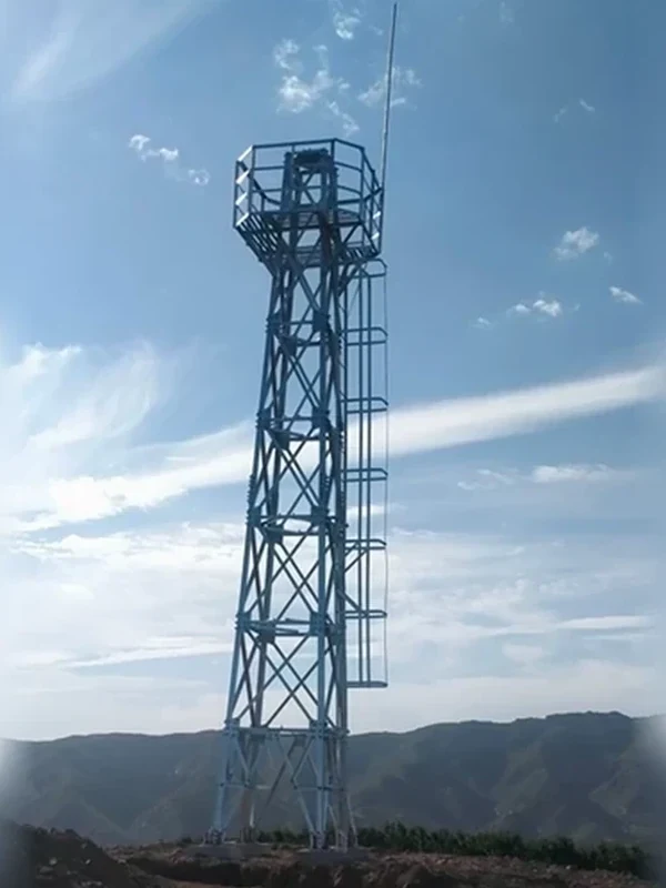 Slim galvanized monitoring tower with square top platform and ladder installed on a mountain ridge