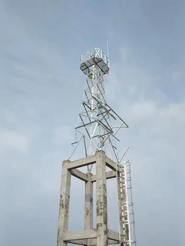 Galvanized lattice monitoring tower mounted on a concrete rooftop frame with access ladder and square equipment platform