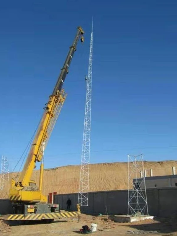Crane installing a tubular lattice lightning protection tower at an industrial site
