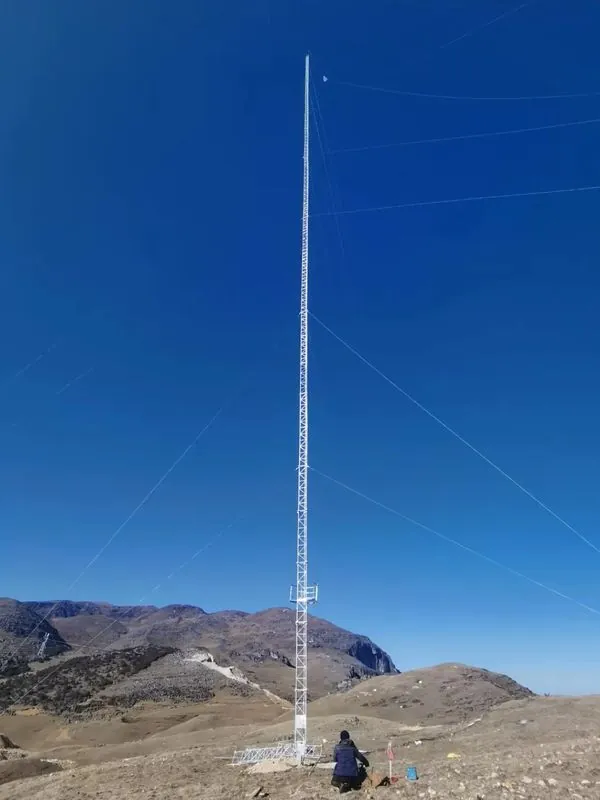 Tall guyed wind measurement tower installed on a mountain ridge